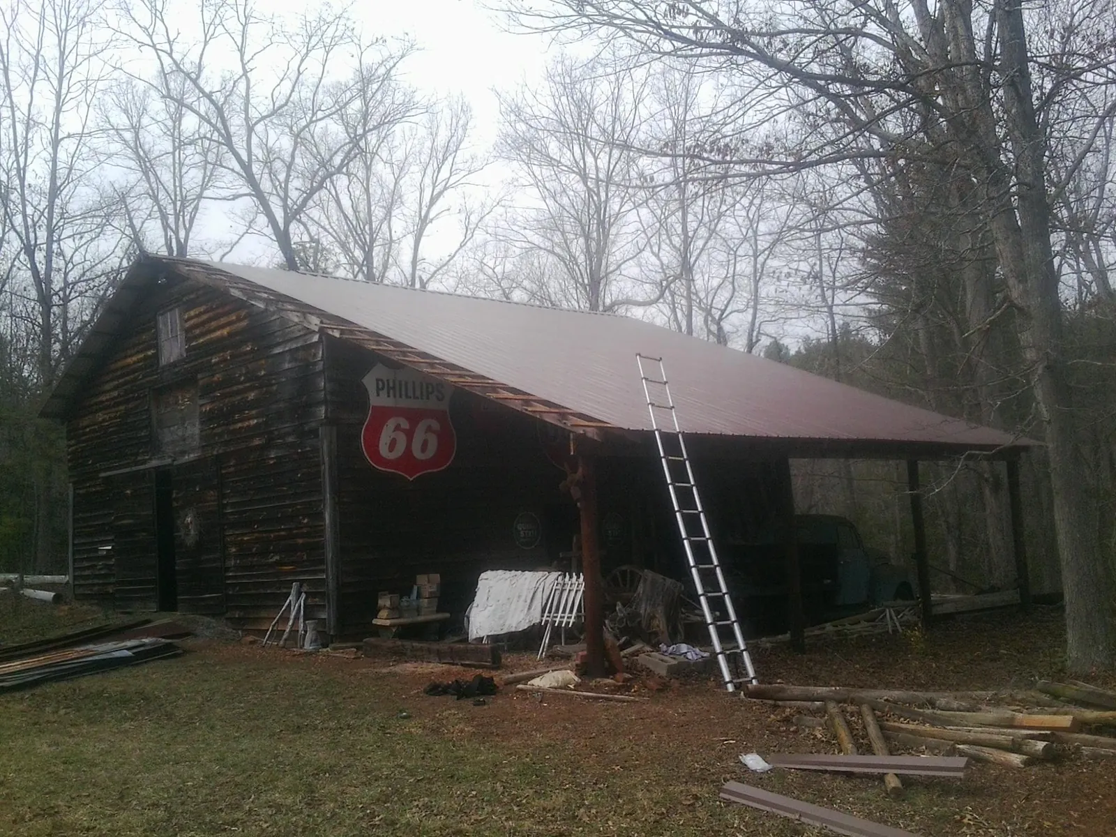 New metal roof on an open sided timber barn with a vintage sign in Fort Payne