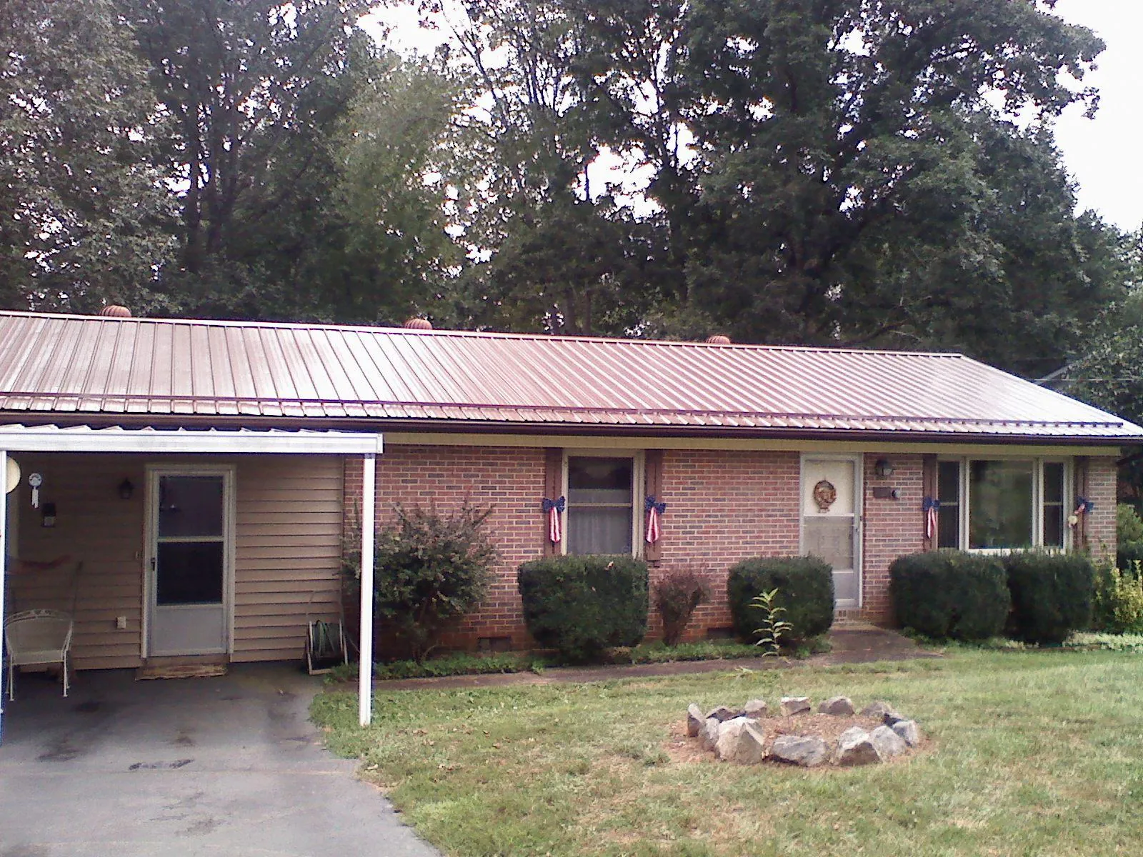 Bronze metal roof and carport on a brick ranch home — Roof Repair work by our crew in Fort Payne