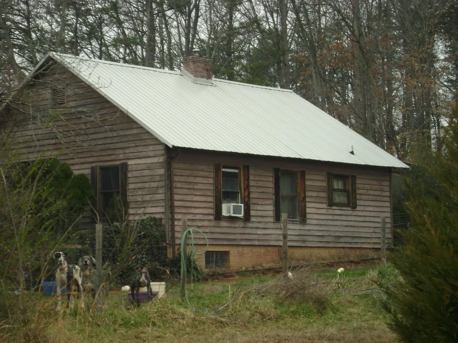 White metal roof on an old wood sided farmhouse, from a Asphalt Shingle Roof Repair job in Fort Payne